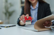© crizzystudio - Businesswoman holding a stamp, preparing to approve an important document while seated at her desk in a corporate office, demonstrating professionalism and attention to detail