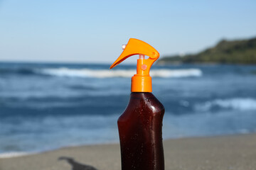 Wall Mural - Bottle of sunscreen cream on sand near ocean at beach