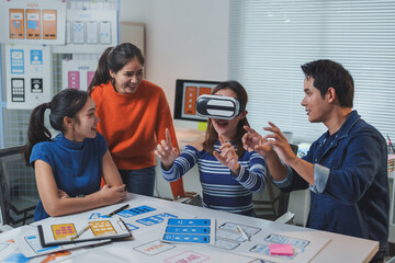 Wall Mural - asian software developers team testing virtual reality application in modern office, woman wearing v