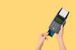 © Pixel-Shot - Woman with credit card and payment terminal on yellow background