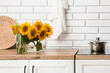 © Pixel-Shot - Sunflowers in vase on kitchen counter