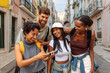 © bernardbodo - Group of tourists laughing together while using smart phone in lisbon