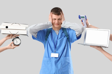 Poster - Stressed male medical intern and hands with things on light background