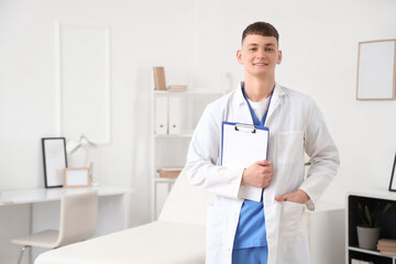 Wall Mural - Male medical intern with clipboard in clinic