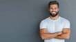 © Maksym - A bearded man with a joyful expression stands confidently in a casual t-shirt. His bright smile and relaxed arms-crossed pose reflect positivity and self-confidence.