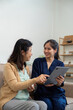 © Natee Meepian - Elderly woman smiling while interacting with her caregiver over a tablet