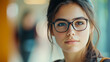 © ABF_MATEO - Young woman wearing glasses in soft focus. Calm expression, warm lighting, and natural beauty enhance the portrait.