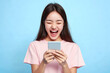 © Tony A - Excited young woman reacting to smartphone news