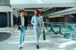 © Jacob Lund - Two male corporate coworkers walking in modern office building
