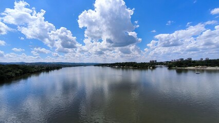 blue sky with white clouds reflected in y=the danube river in novi sad