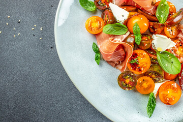 prosciutto salad, cherry tomatoes, and cream cheese with basil leaves, antipasto, restaurant menu, d