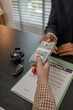 © kamiphotos - the car sale is completed after the contract is signed, hand over the car key after purchasing the car, pay the car price to the car salesperson at the showroom