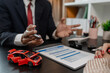 © kamiphotos - a lawyer is explaining the details of a car insurance policy to the car owner before she signs it, a lawyer explains to his client what will happen if she doesn't get car insurance