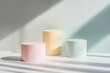© Kristina - A set of minimalist cylindrical product podiums in pastel colors with a dramatic light and shadow backdrop for mockup