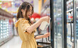 © Art_Photo - Portrait of beauty asian happy woman relax and enjoy shopping time with trolley cart buy healthy food fresh dairy product of milk and cheese in commercial refrigerators at shopping supermarket