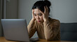 © Benjamin - Frustrated, overwhelmed young woman gripping head while staring at laptop screen, feeling anxiety, exhaustion, and confusion over unexpected error.