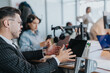 © qunica.com - Group of diverse employees working collaboratively at a modern office setting, focused on active discussions and technology. Highlighting teamwork, business communication, and innovation.