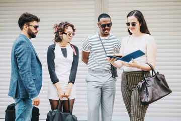 Wall Mural - A group of diverse business people engaging in an outdoor meeting, brainstorming ideas and discussing strategies for growth. The setting is urban, indicating a modern approach to collaboration.