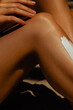 © Mirrorstudio - Close-up of female leg with sun cream on skin in natural light setting. Skin care, sun protection