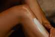 © Mirrorstudio - Applying sunscreen on female leg for skin protection and moisturization. Skin care, sun protection