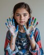 © Arceli - A teenage female artist in casual clothes with paint on her hands close up portrait on plain background