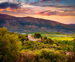 Wall Mural - dramatic summer sunset on ancient butrint venetian castle. picturesque evening view of butrint natio