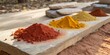 © STUDIO MELANGE - Vibrant spices arranged on a natural stone surface in an outdoor setting during daylight