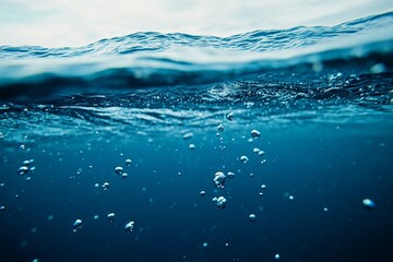 Wall Mural - underwater view of bubbles rising through calm ocean water surface