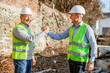 © Marko - Two Construction Workers Shake Hands In Front Of Brick Wall