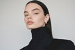 © World of AI - woman wearing strong, minimalist look featuring a black structured blazer over a high-neck turtleneck.