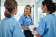 © MT - Three Female Healthcare Professionals Engaging in a Collaborative Discussion in a Modern Medical Facility During Daytime