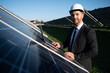 © Serhii - Solar power plant. Man standing near solar panels. Renewable energy