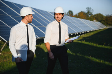 The solar farm, solar panel with two engineers walk to check the operation of the system, Alternative energy to conserve the world's energy, Photovoltaic module idea for clean energy production