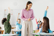 © Home-stock - Excited diverse schoolchildren raising their hands to answer teacher questions during the lesson, teacher looking at kids and smiling