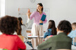 © Home-stock - Smiling young female teacher giving high five to her pupils, after last lesson of school year. Education, teaching, learning and end of school year concept