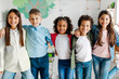 © Home-stock - Group of happy diverse school friends embracing and smiling at camera, posing in classroom at the last school day