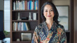 © DOUGLAS - woman in patterned kimono stands confidently near bookshelf, exuding elegance and professionalism. room is softly lit, with books and decor visible in background