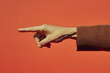 © ruangrit19 - Gesture of Pointing Finger on Bright Orange Backdrop