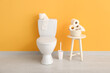 © Pixel-Shot - Ceramic toilet bowl, brush and rolls of paper near color wall