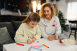 © Zamrznuti tonovi - Daughter drawing mother's day card with her mother watching her