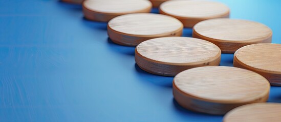 Leinwandbilder - Wooden tokens arranged in a line on a blue surface, showcasing a clean, minimalistic design with soft shadows and a smooth texture.