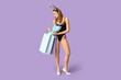© Pixel-Shot - Sexy young woman in bunny ears with shopping bags on lilac background. Easter celebration