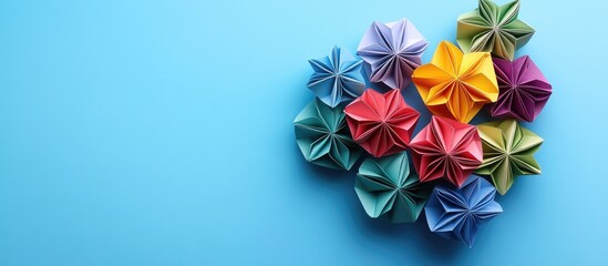Poster - Colorful origami flowers arranged in a cluster on a light blue background featuring shades of red, purple, yellow, green, and turquoise.