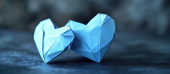 Poster - Blue origami hearts in the foreground on a textured dark background with soft focus highlighting their geometric shapes and intricate folds.