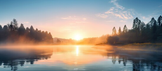 Aufkleber - Serene sunrise over calm river reflecting pastel colors with mist rising, surrounded by trees in the early morning light.