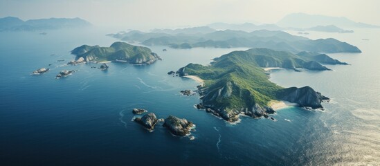 Aufkleber - Aerial view of a turquoise sea strait between lush green islands under soft sunlight with distant mountain silhouettes in the background.