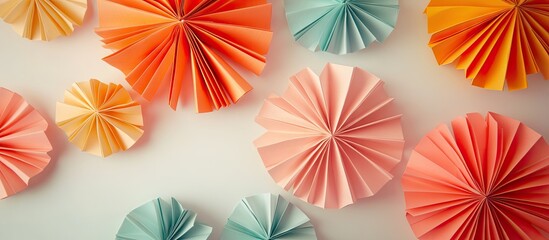 Poster - Colorful origami paper flowers in shades of orange, pink, and blue arranged in circular patterns on a light background highlighting their texture.
