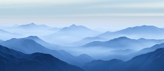 Aufkleber - Serene blue mountain landscape shrouded in soft fog with layered peaks fading into the horizon creating a tranquil and calming atmosphere.