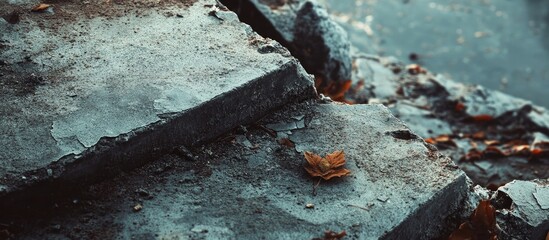 Leinwandbilder - Serene close-up of textured stone steps with vibrant autumn leaves against a blurred water background featuring soft natural tones and rustic details.