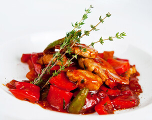 Wall Mural - Chicken fillet with vegetables on a white plate being decorated with thyme sprigs